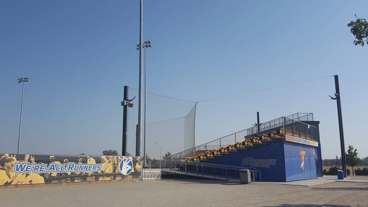 Hardt Field bleachers and backstop on the CSU Bakersfield campus, with Roadrunners branding and a paved forecourt.
