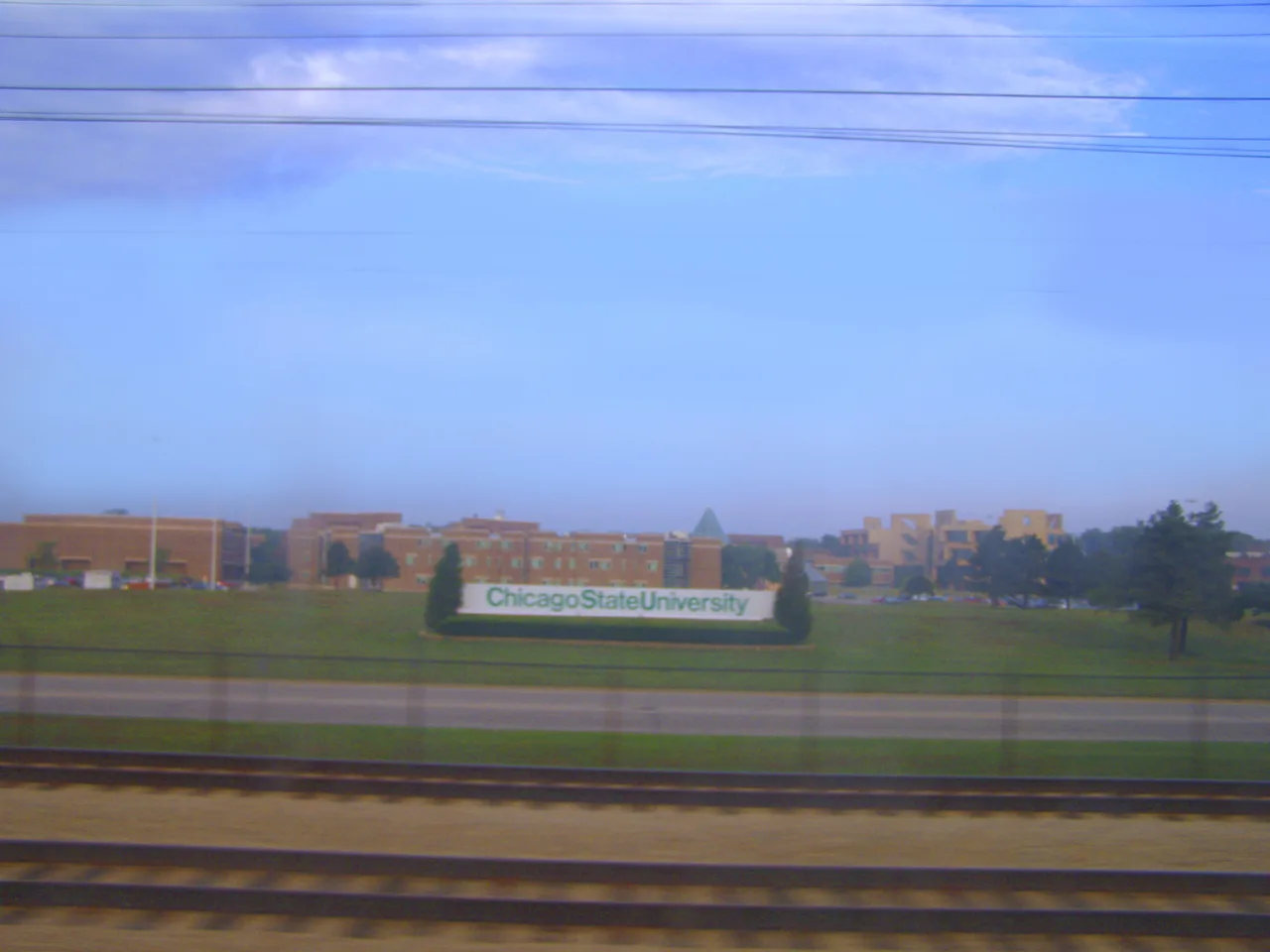 Chicago State University sign and campus buildings viewed from the South Shore Line.