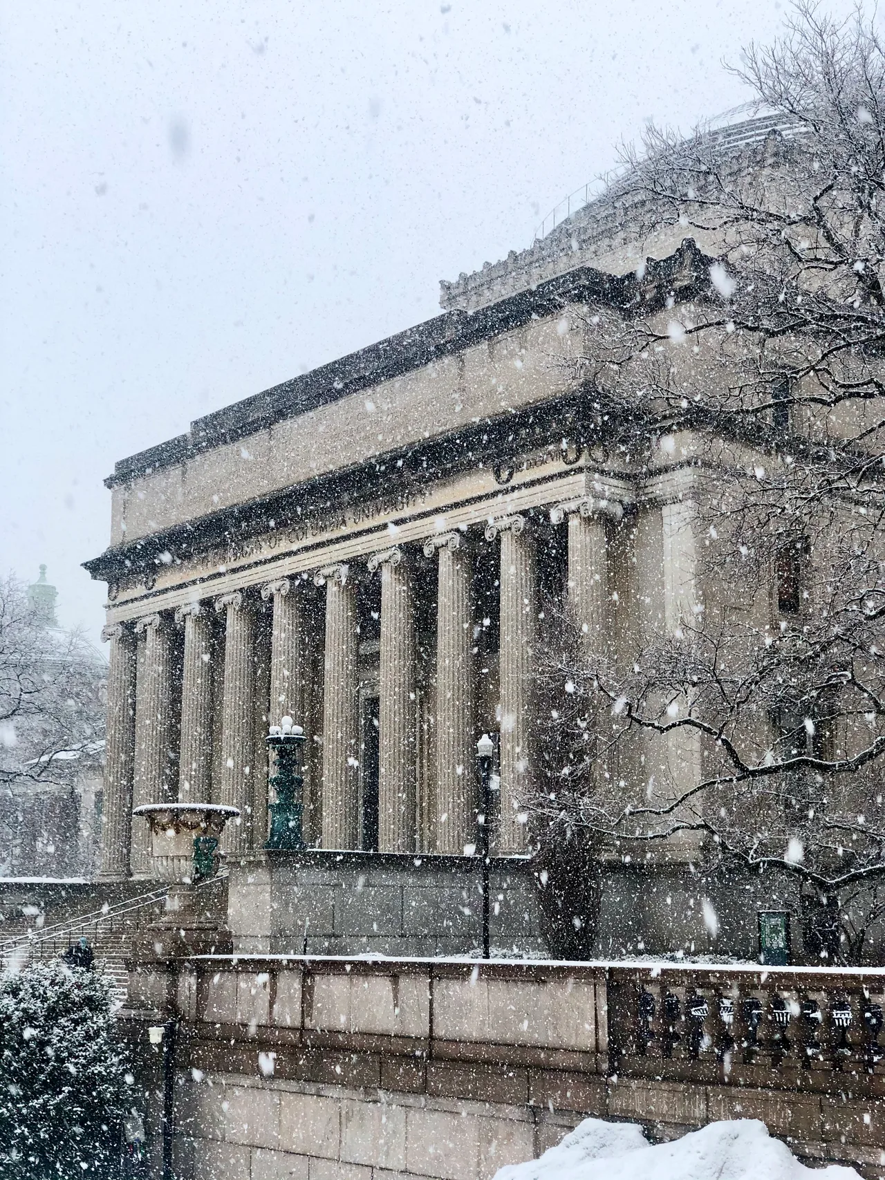 Low Library’s columns and dome during snowfall at Columbia University.