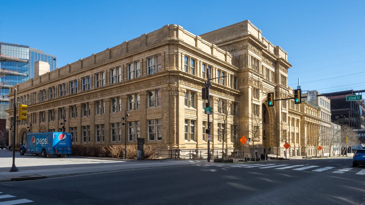 Ornate facade and main entrance of Drexel University’s Main Building beside city streets in Philadelphia.