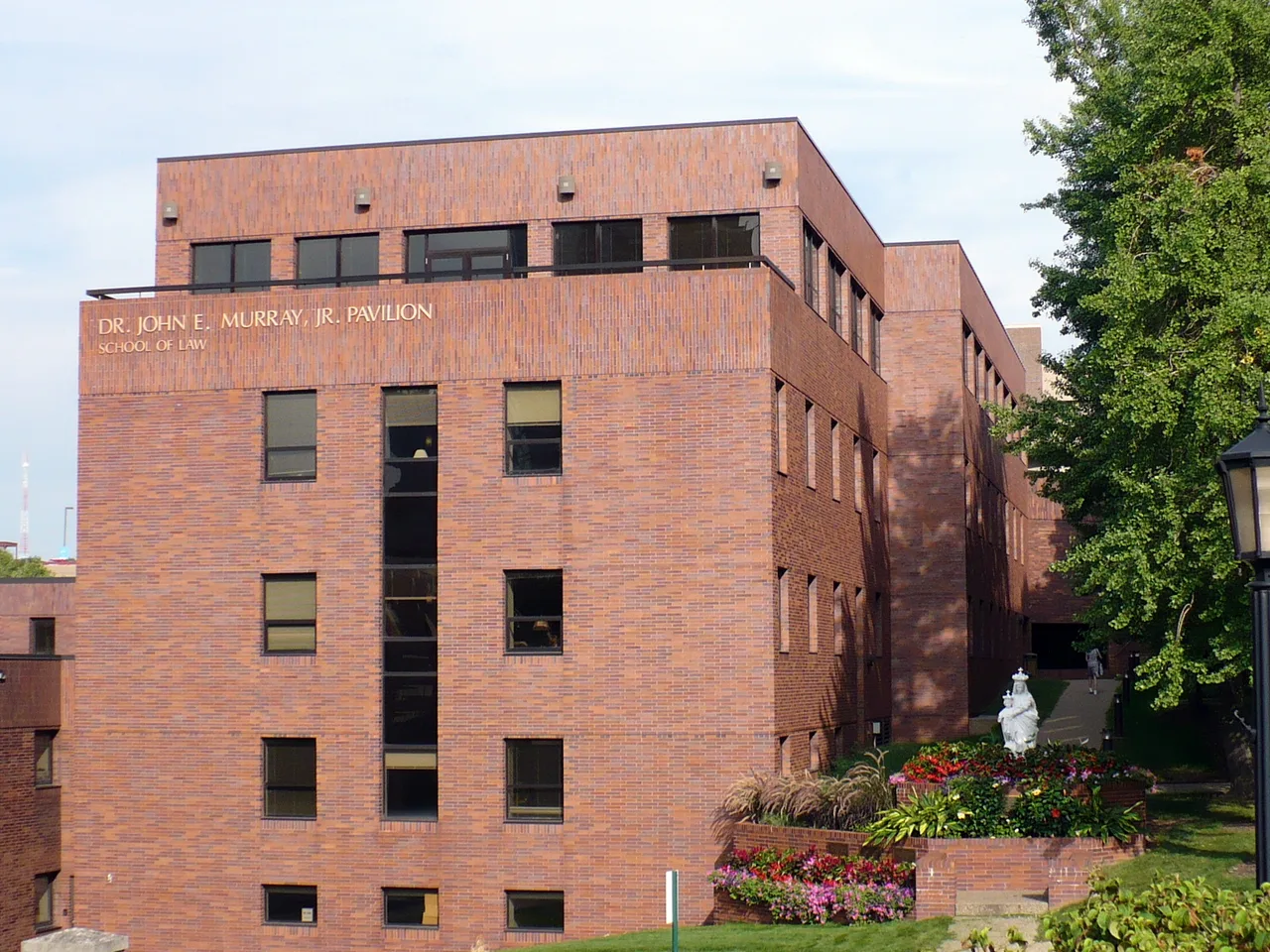 Brick law-school building with pavilion lettering and landscaped flower beds at Duquesne University.