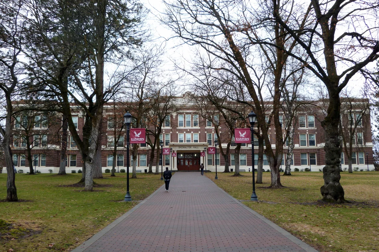 Campus walkway leading through bare trees to Showalter Hall at Eastern Washington University in Cheney, Washington