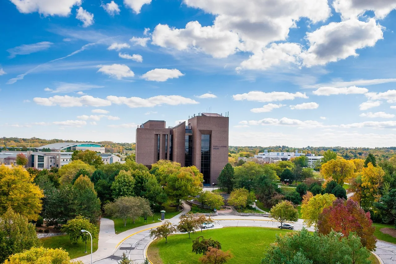 Cofrin Library centered among autumn trees, campus buildings and paths at the University of Wisconsin–Green Bay.