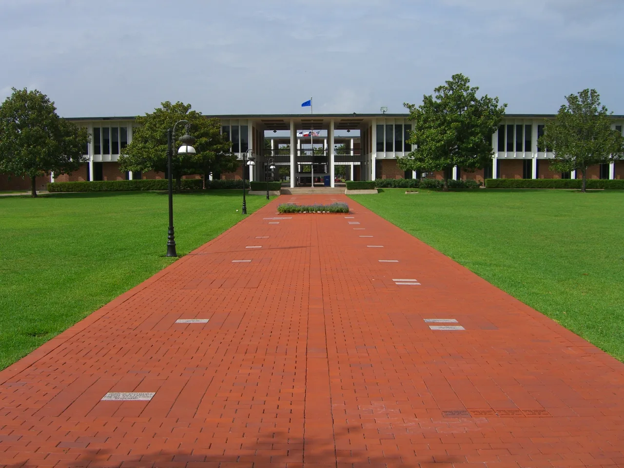 A red-brick campus walk and lawns leading to the Brown Administrative Complex at then-named Houston Baptist University, now Houston Christian University, in July 2008.