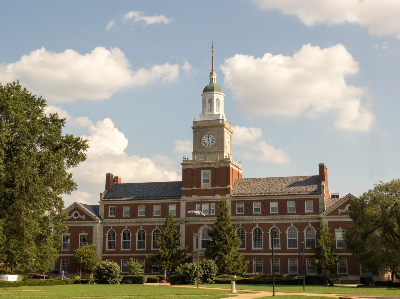 Founders Library’s brick facade and central clock tower beyond campus lawns at Howard University.