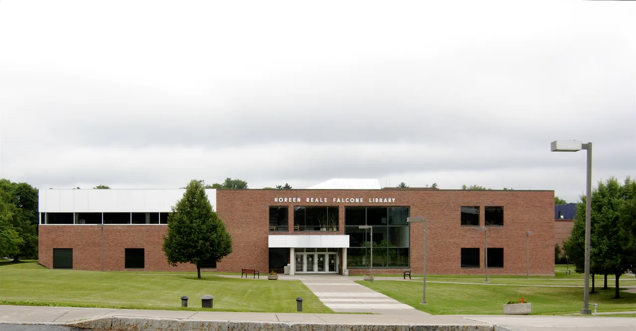 The brick library facade and entrance beyond a green lawn at Le Moyne College in Syracuse, New York.