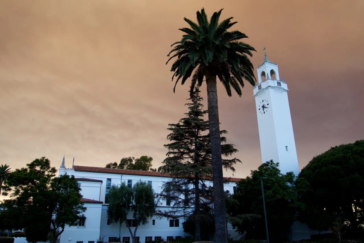 The white chapel tower and campus exterior behind palm trees at Loyola Marymount University in a 2016 photograph.