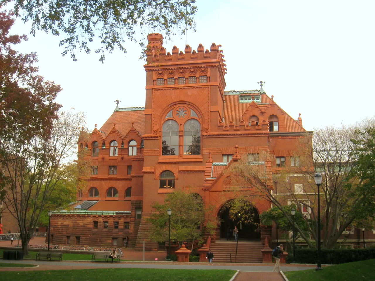 Red masonry facade and tower of Fisher Fine Arts Library at the University of Pennsylvania, framed by trees.